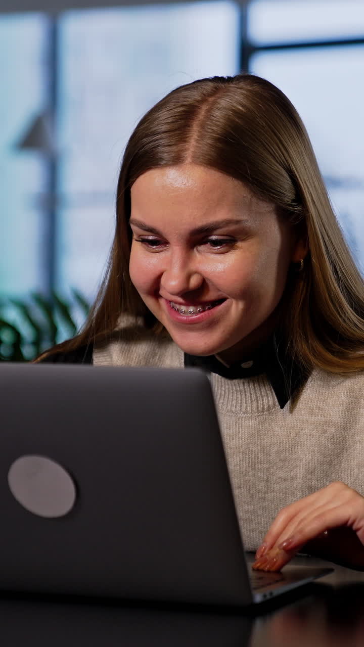 Resilient smiling young woman working on her computer. Happy lady is ...