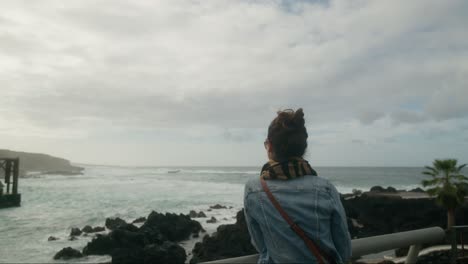 Mujer-Turista-Disfrutando-De-La-Vista-De-Las-Olas-Rompiendo-En-La-Costa-Rocosa-De-La-Ciudad-De-Garachico-En-Tenerife,-Islas-Canarias