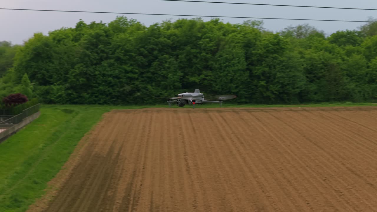 Professional drone flying over plowed field for agriculture analysis, monitoring and surveillance