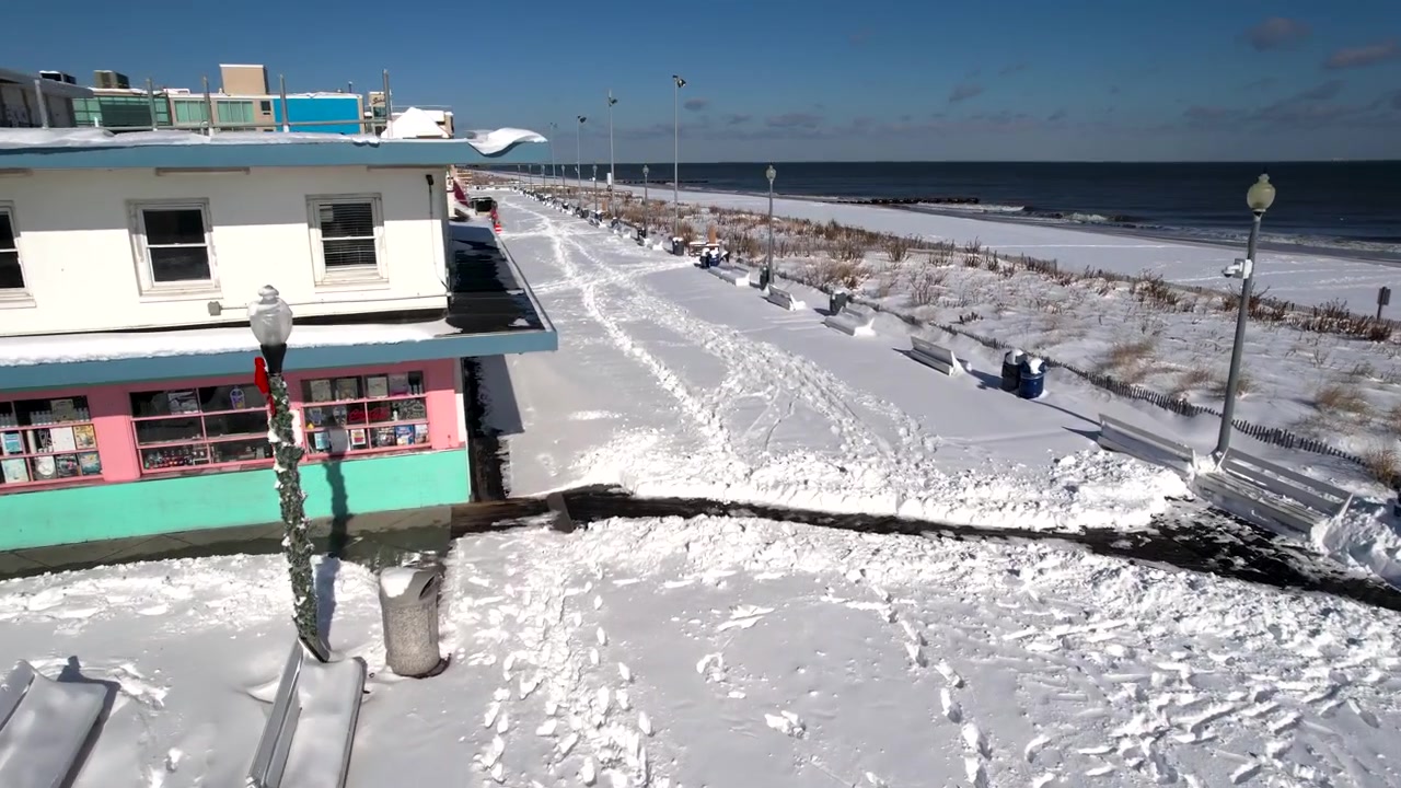 Snow on boardwalk drone flyover Rehoboth Beach Delaware