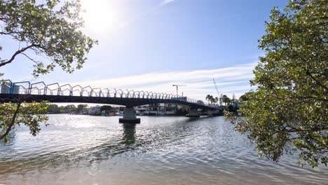 a boat moves under a bridge