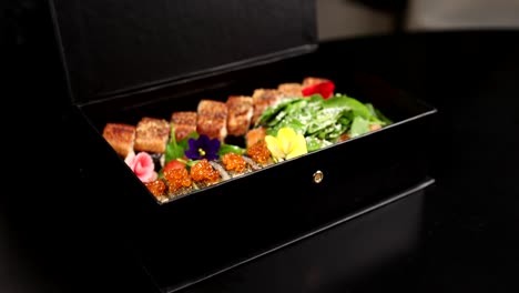 chef presenting a exquisite plated dish in a black box