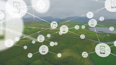 animation of connected icons over aerial view of water stream on green land against cloudy sky