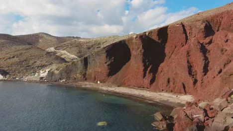 4k drone aerial view of the beautiful red beach in santorini