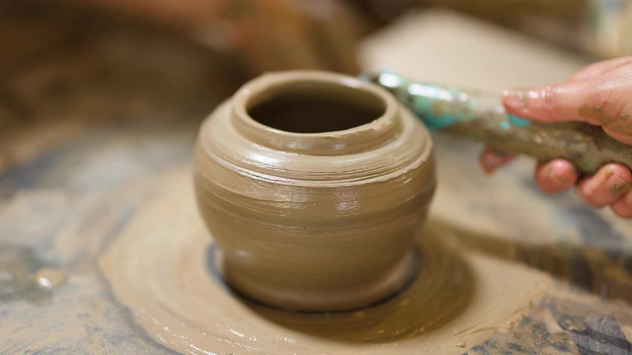 Primo piano di un vasaio che usa strumenti per modellare un vaso di ceramica a Nonthaburi, Thailandia.