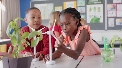 conducting science experiment with wind turbine model, children in school classroom