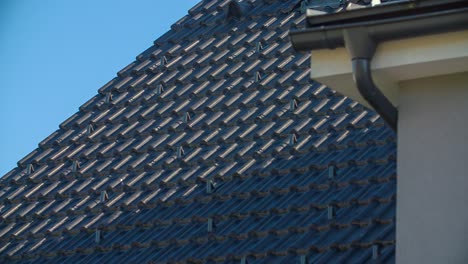 View-of-new-modern-roof-with-shiny-black-roof-tiles-on-sunny-day