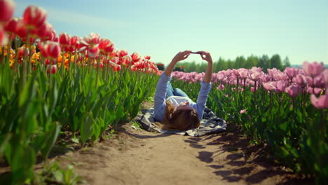 Chica-Guapa-Sosteniendo-El-Teléfono-Móvil-En-Las-Manos-En-Un-Jardín-De-Flores-En-Un-Día-Soleado.