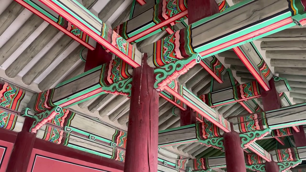 Edificio palaciego elaborado con columnas de madera tradicionales asentadas sobre bases de piedra, visto en el interior de Jinseonmun, Palacio de Changdeokgung.
