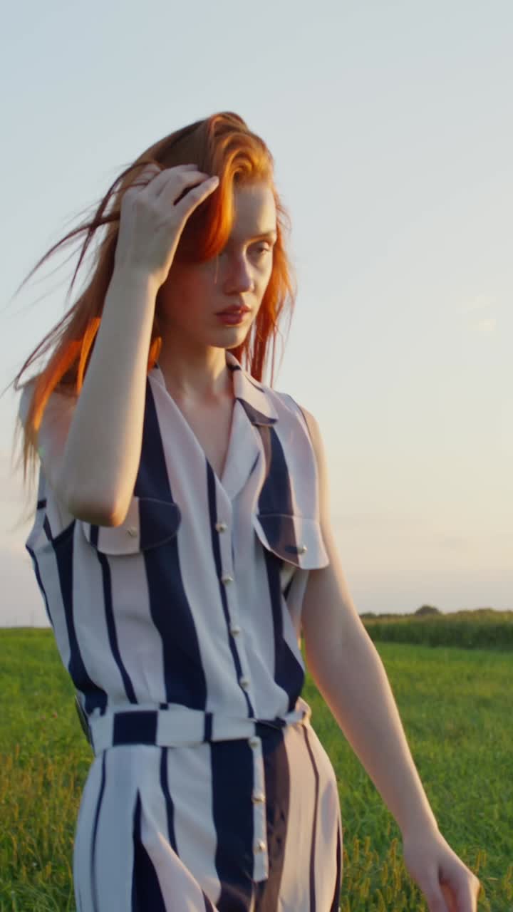 해가 지는 동안 줄무 옷을 입은 여자