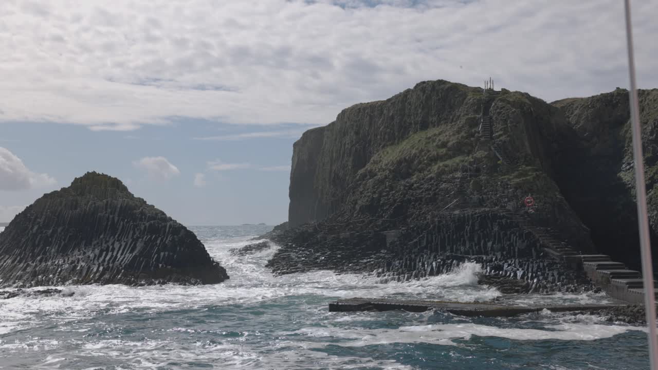 Hand-held shot of large waves crashing onto the jetty at the Isle of Staffa