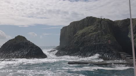 Handaufnahme-Von-Großen-Wellen,-Die-Auf-Den-Steg-Auf-Der-Insel-Staffa-Krachen