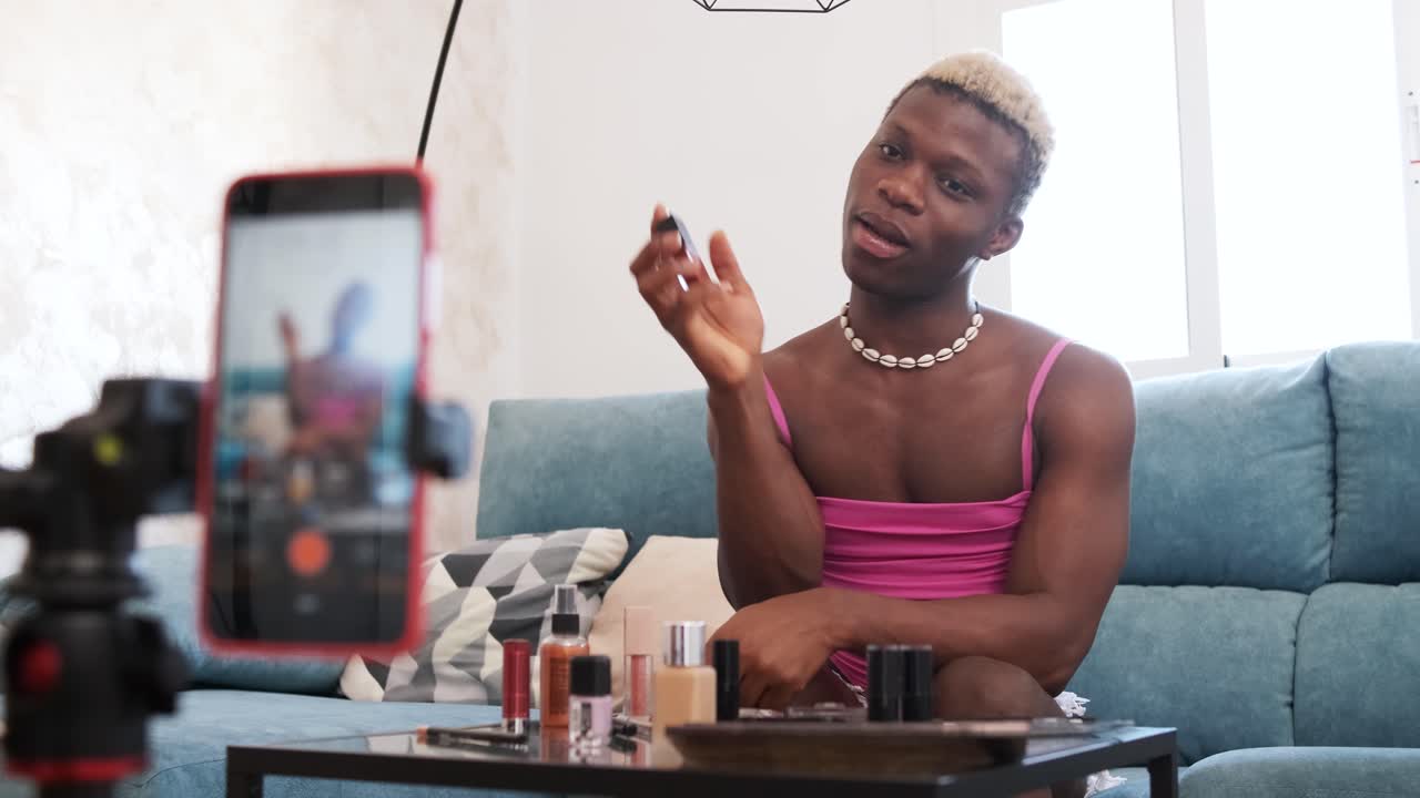 Young man filming a makeup tutorial for his online channel