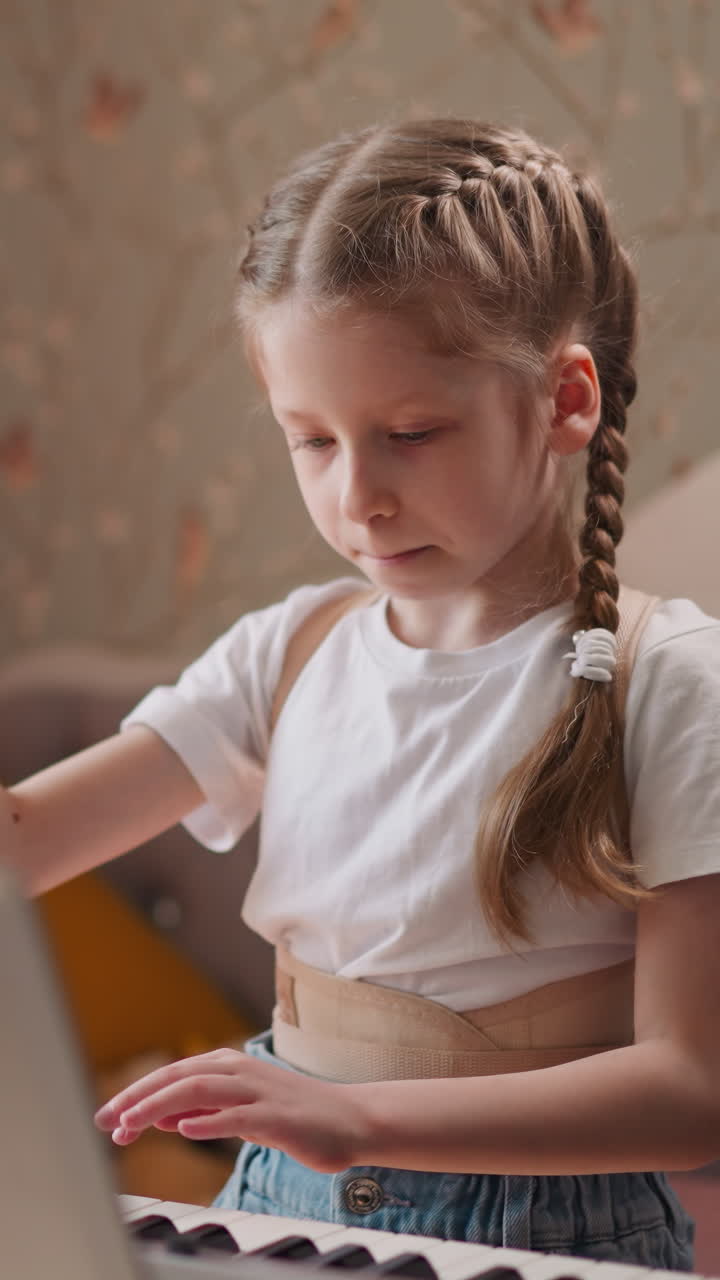 Thoughtful girl practices piano at home undergoing rehabilitation after spinal injury. Musician flips through pages with notes carefully looking for composition to play