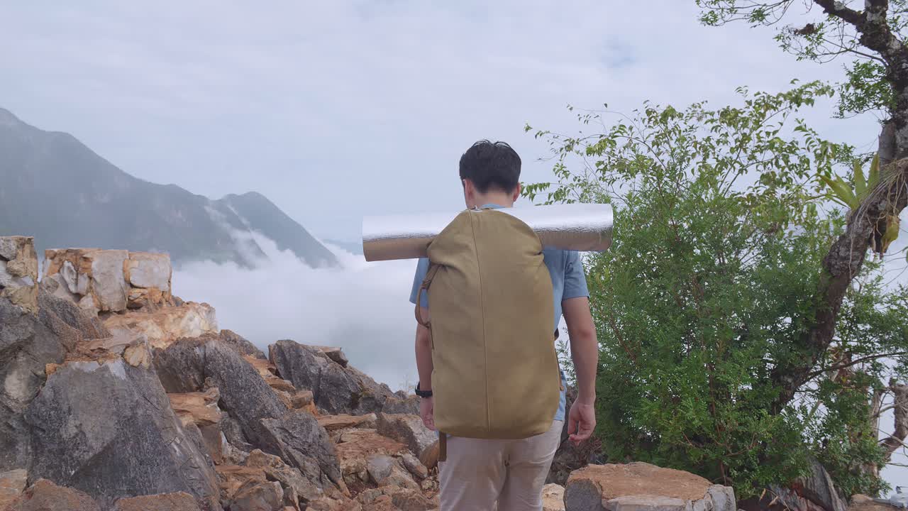 안개 가득 한 산 을 산책 하는 배 을 들고 있는 아시아 사람