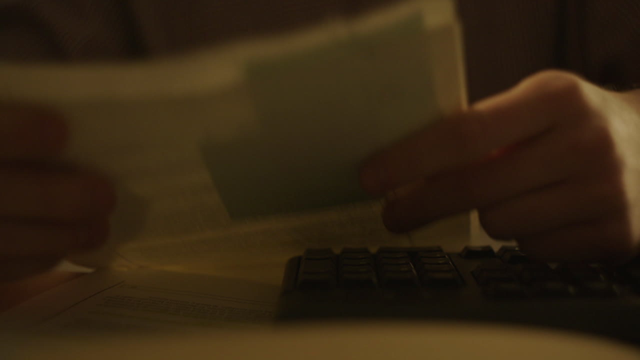 Person working on documents at a computer at night