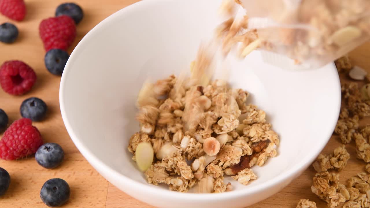 poner granola en un bol para un desayuno de cereales