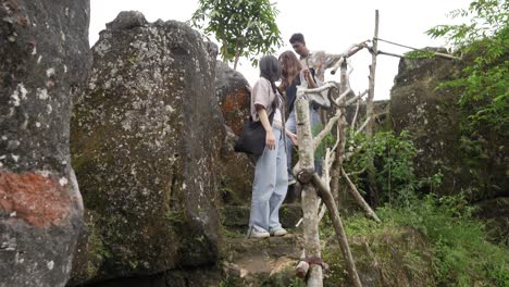 young asian indonesian friends hiking down rocky trail in lush nature, outdoor adventure travel