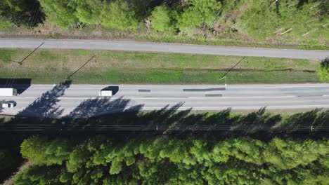 Ascending-aerial-looks-directly-down-onto-vehicles-on-rural-highway