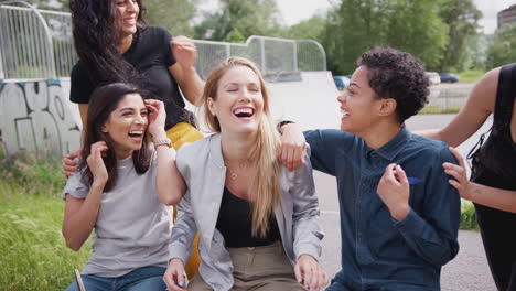 women surprise three female friends talking and laughing in urban skate park