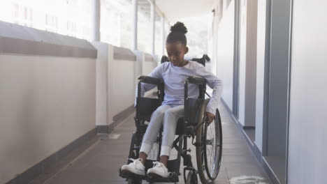 navigating school hallway, african american girl in wheelchair moving independently, smiling confide