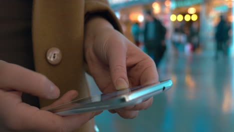 Woman-hands-typing-on-mobile-at-the-station