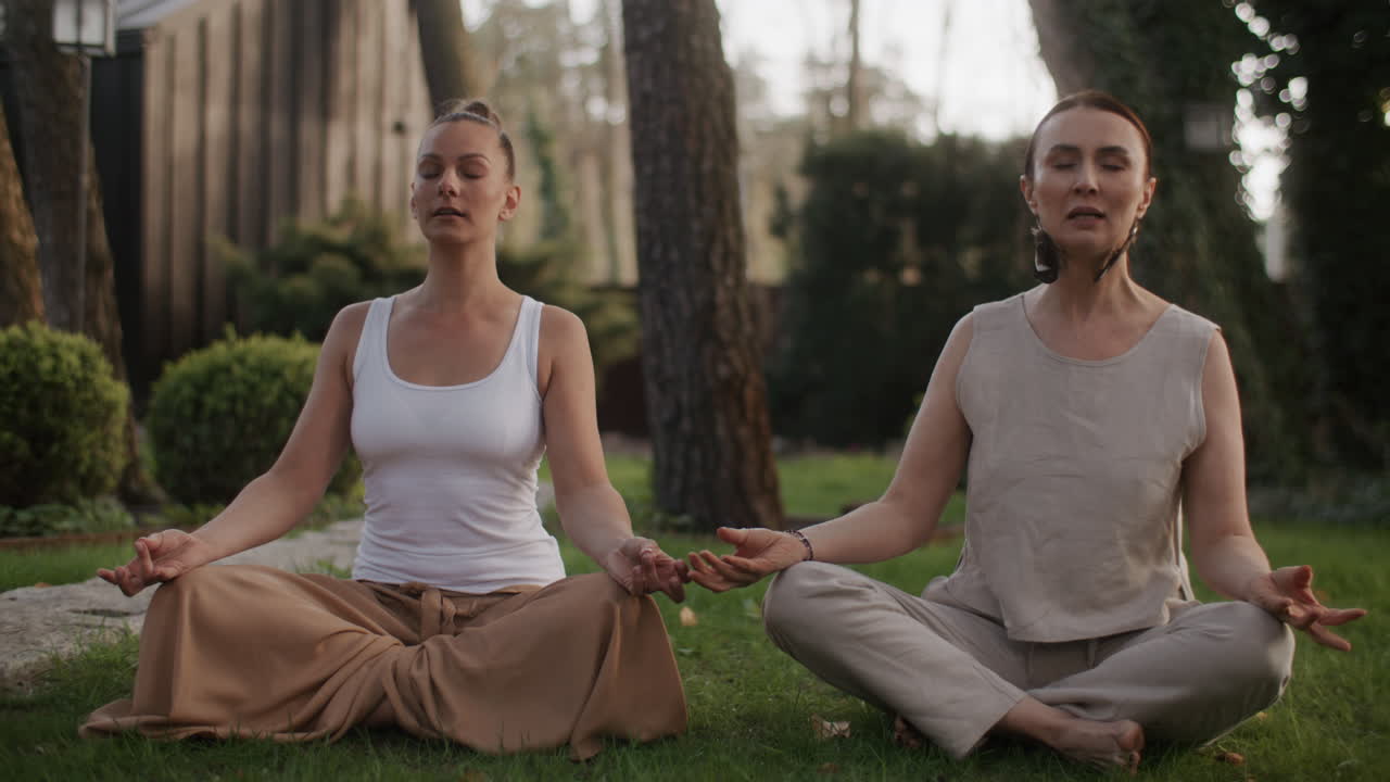 dos mujeres meditando al aire libre