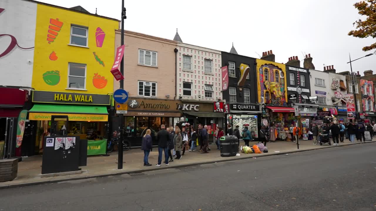 Colorful storefronts and vibrant street life in Camden Town, London on an overcast day