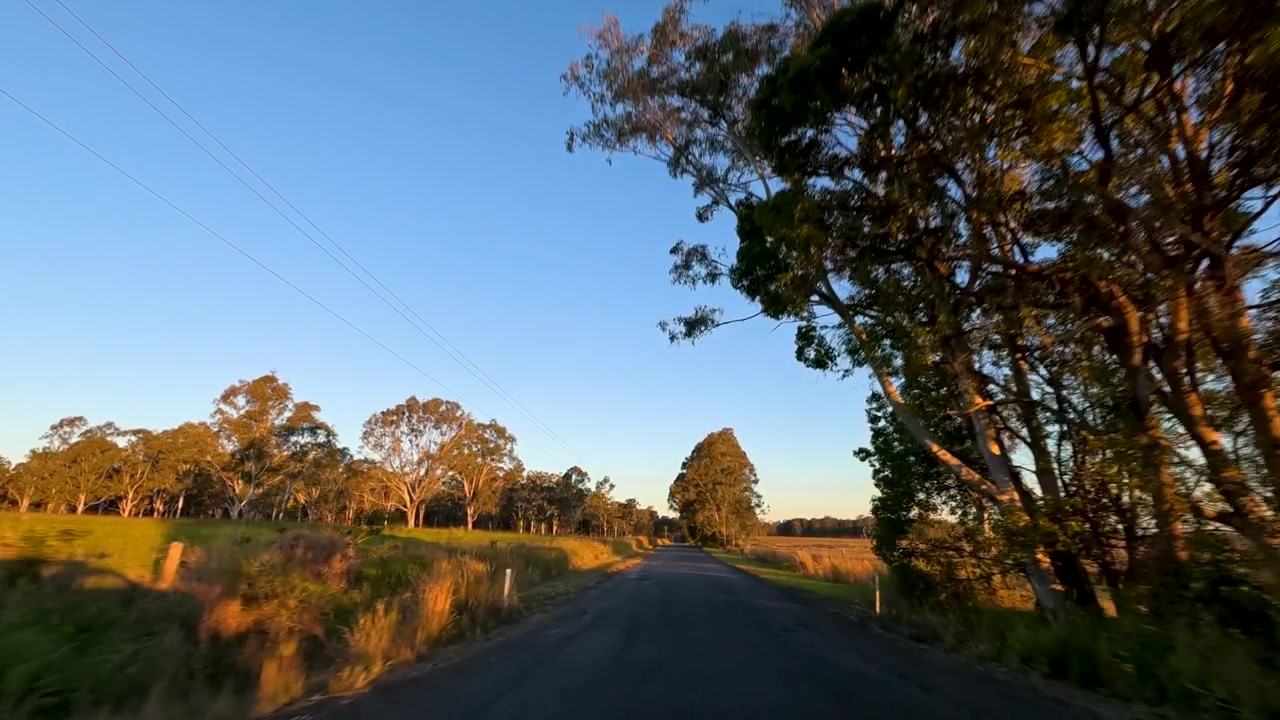 Ich-Perspektive: Fahrt auf einer Landstraße bei Sonnenuntergang im Pillar Valley, Australien.