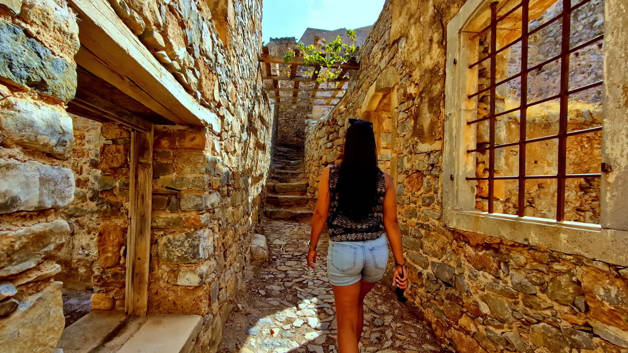 Woman walking through ancient stone ruins