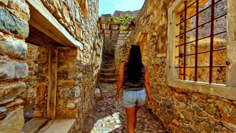 woman walking through ancient stone ruins