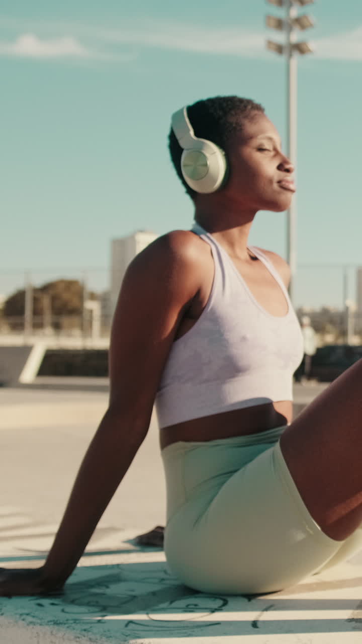 Donna in abbigliamento sportivo si rilassa all'aperto con le cuffie