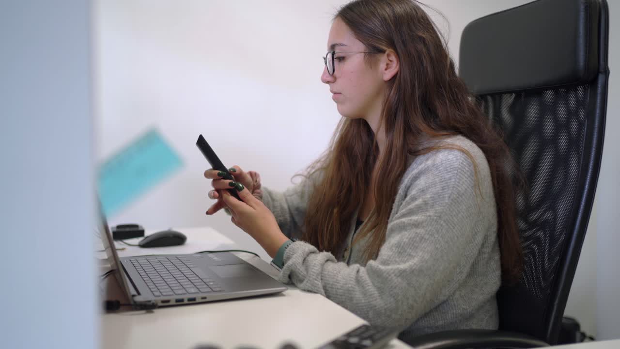 Woman working on computer and having phone call