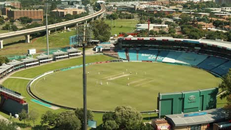 drone aerial footage of a cricket game being played in a cricket stadium