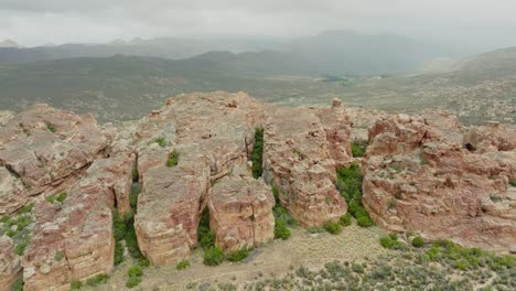 drone flies very high over rock formation in desert landscape cederberg wilderness area in south africa - mountains in clouds can be seen in the background