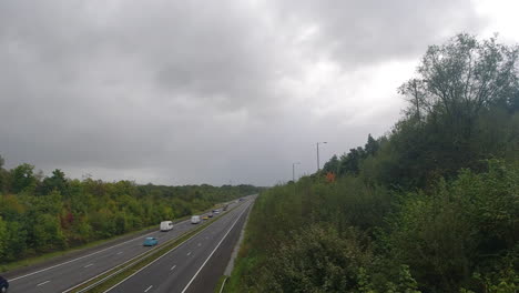 toma estática de la autopista m4 de los autos que pasan y un espectacular cielo nublado oscuro 4k