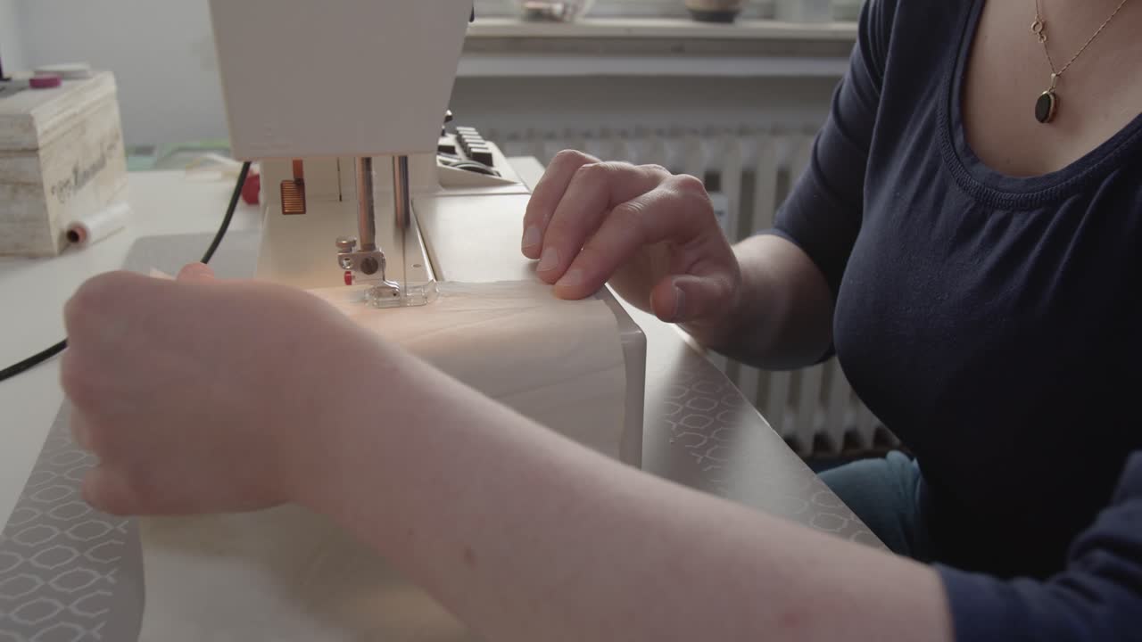 una costurera usa una máquina de coser para hacer máscaras faciales durante la pandemia del coronavirus