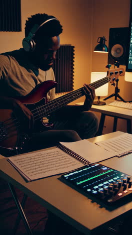 musician playing bass guitar in a home studio