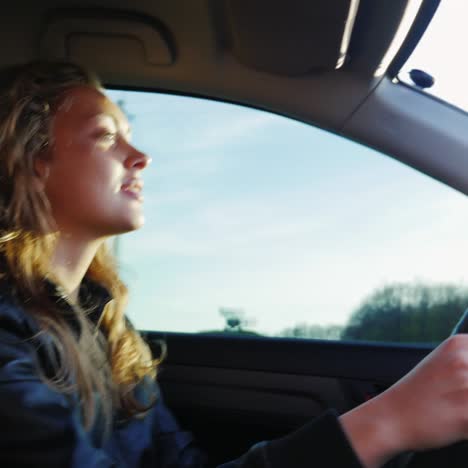 mujer conduce el auto al atardecer