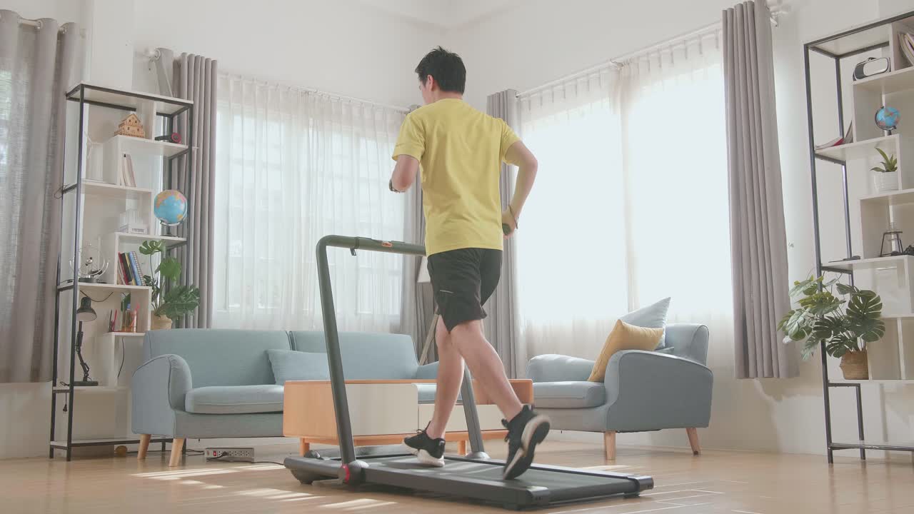 自宅のトレッドミルで走る男性