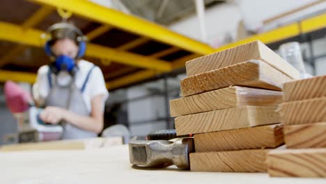 female welder using wood sanding machine 4k