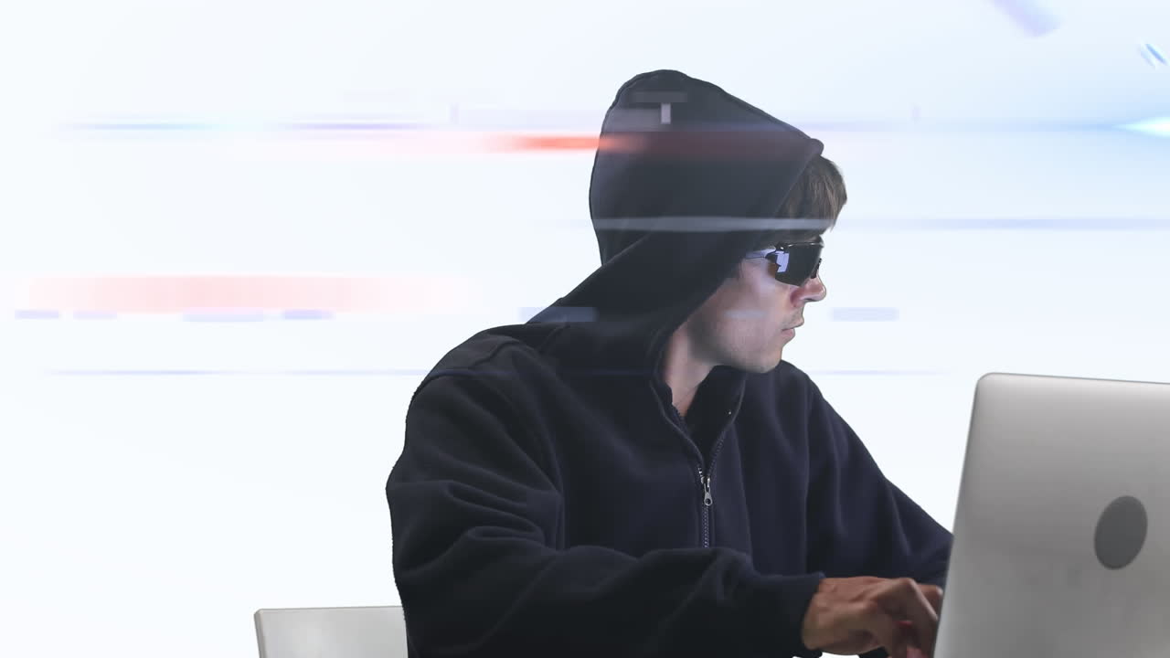 Caucasian hooded hacker man with a laptop over rays glowing