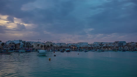 Ein-Blick-Auf-Den-Sonnenuntergang-Einer-Stadt-Am-Wasser-Mit-Bunten-Booten-Im-Meer