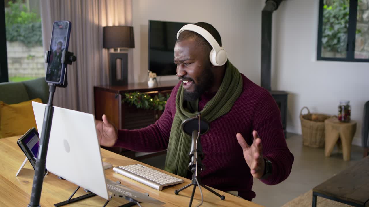 Clicking mouse middle aged African American man starting online session speaking into mic at desk