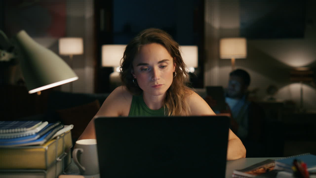 Serious accountant texting home zoom out. Girl preparing weekly report at laptop