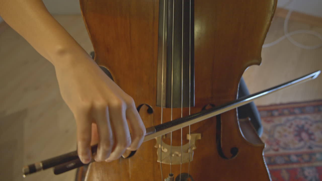 Musician's Hands Bowing Strings of a Cello