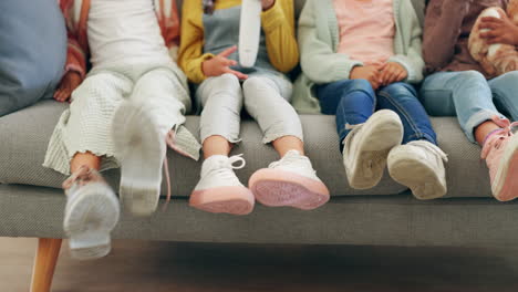 family, feet and kids watching tv in the living