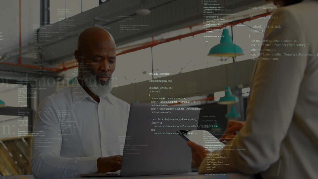 Project manager showing overlaid code on tablet and engineer typing on laptop in software review