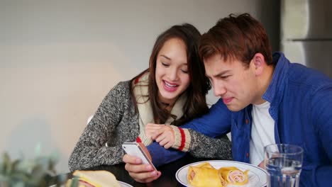Paar-Benutzt-Mobiltelefon-Beim-Frühstück
