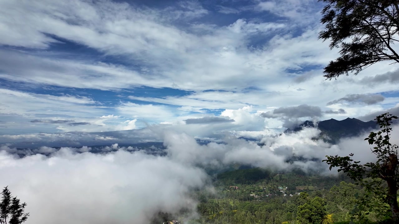 A stunning landscape of fluffy clouds hovering above lush green highlands in Sri Lanka, capturing the essence of tranquility and natural beauty.